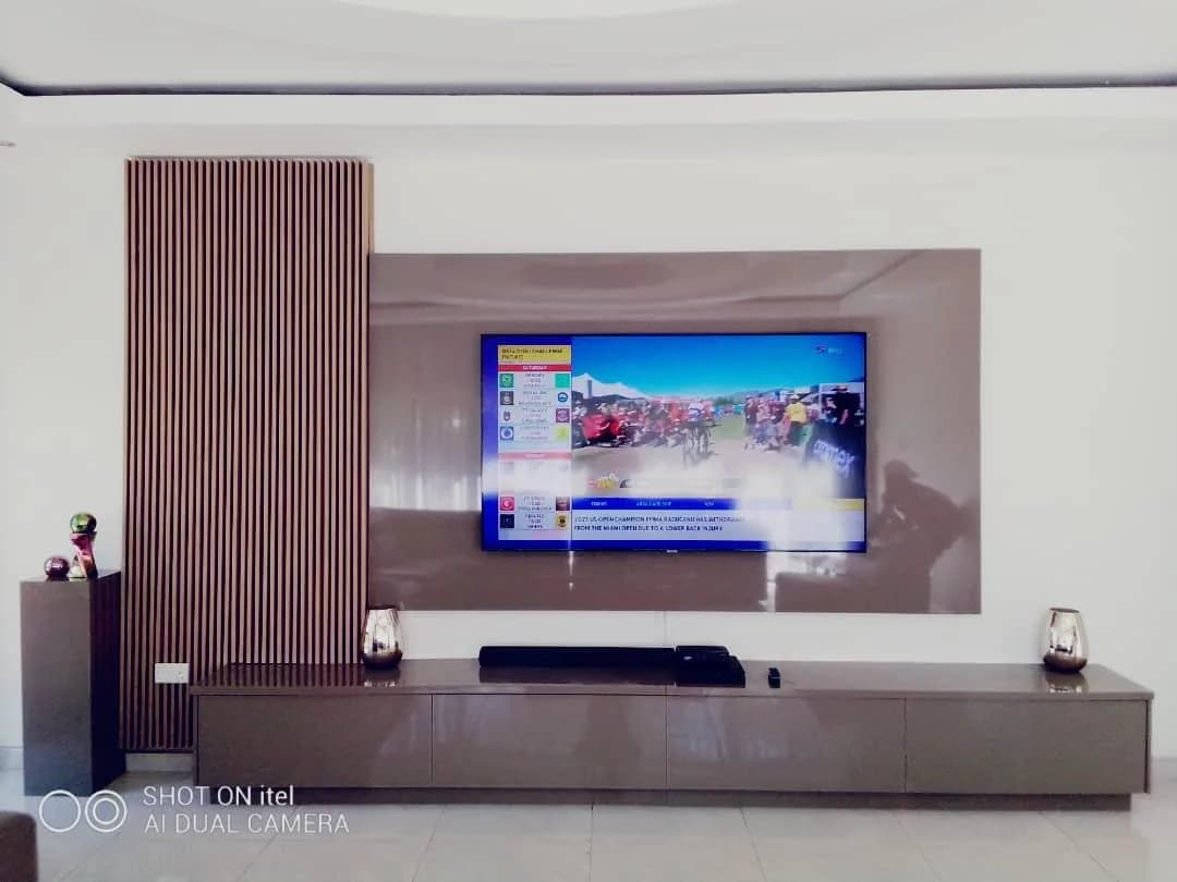 TV wall with vertical timber slats, a panelled backdrop and a long media unit