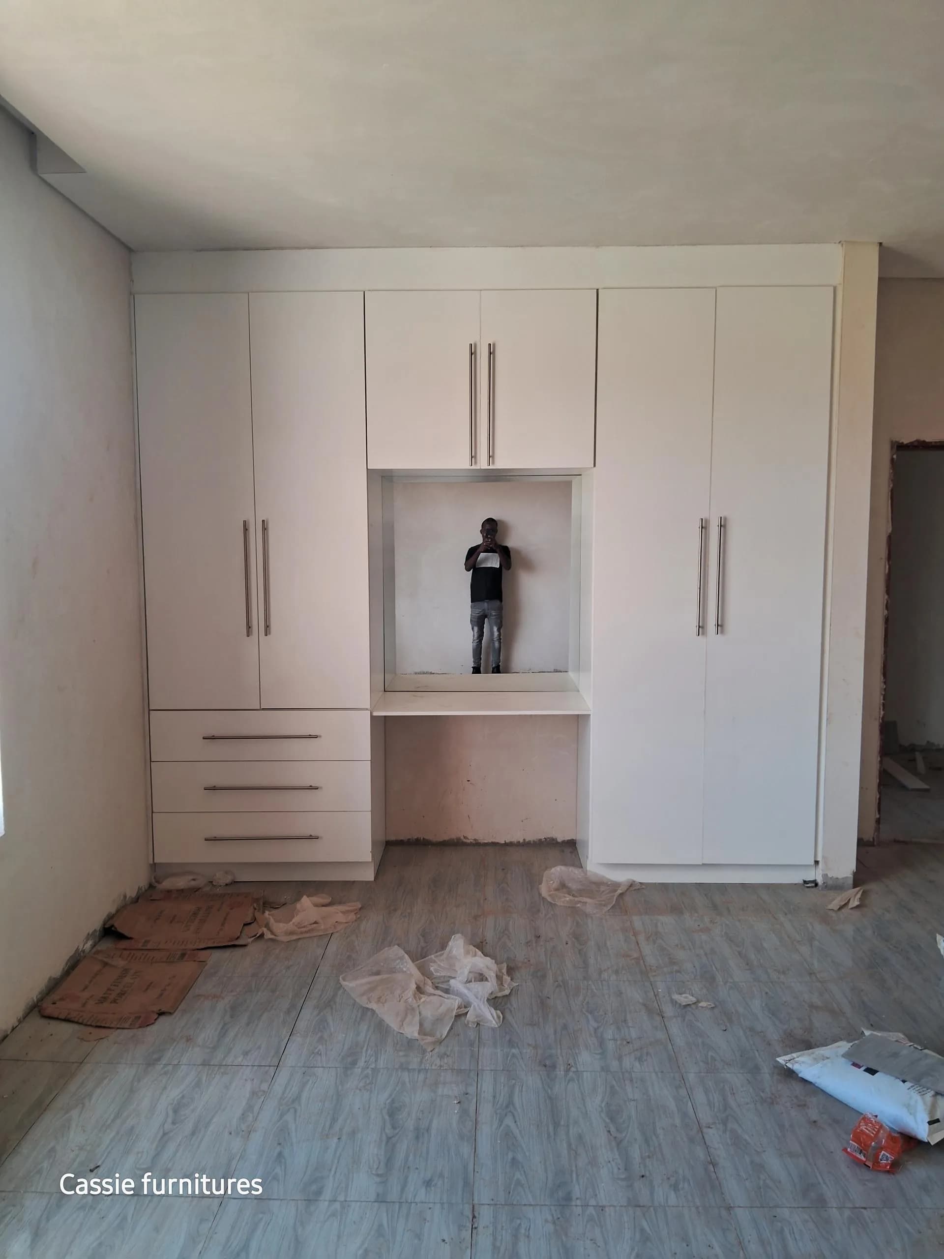 White built-in wardrobes with a central desk niche and drawers