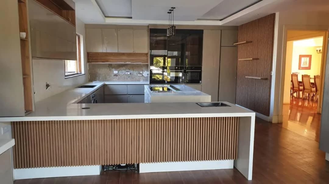 Open-plan kitchen with a timber-slatted island and built-in appliance wall